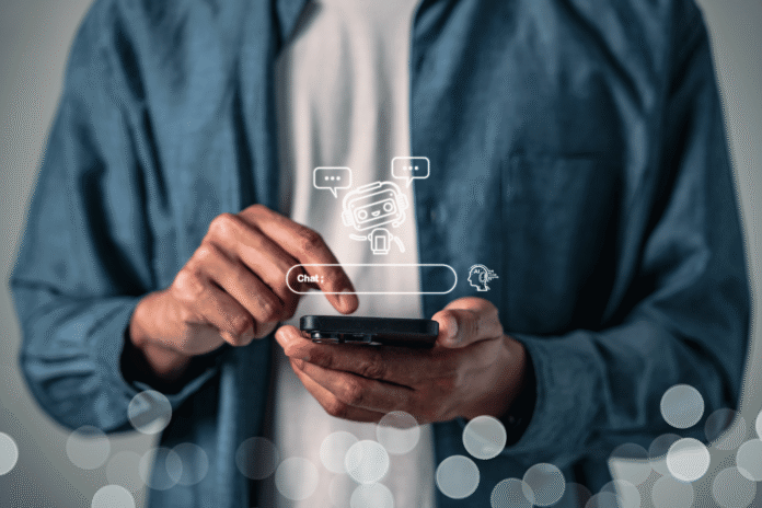 Osoba drži telefon i proverava podatke na providnom digitalnom ekranu