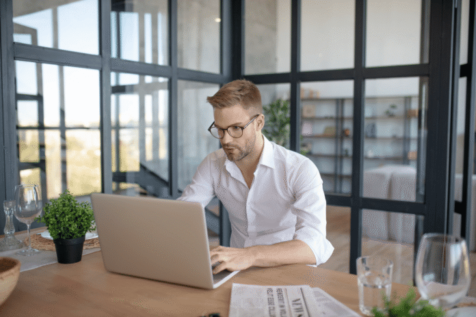 Vlasnik male firme podešava AI chatbot na laptopu u kancelariji