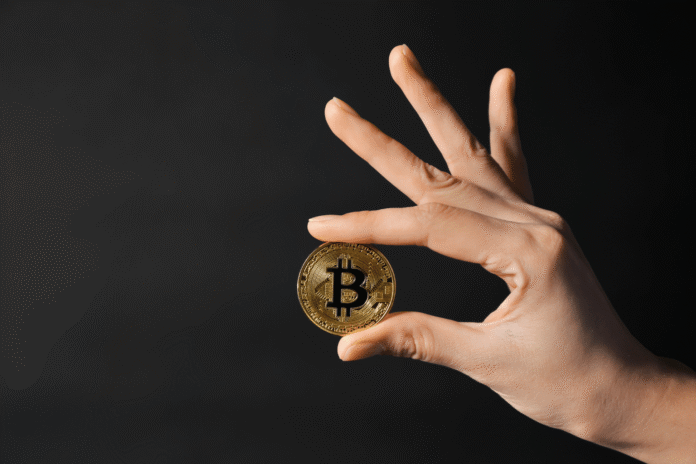 Ruka drži zlatnu Bitcoin kovanicu