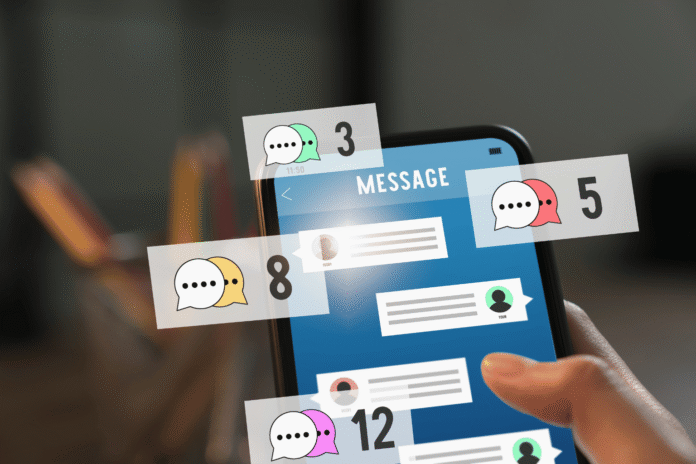 Ruka drži telefon sa porukama i AI chat ikonicama, simbol glasovnih agentskih funkcija u ChatGPT mobilnoj aplikaciji