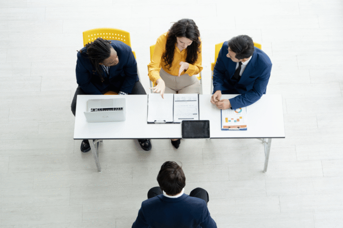 Grupa poslovnih ljudi razgovara za stolom, simbolički prikaz investicione runde za AI startap